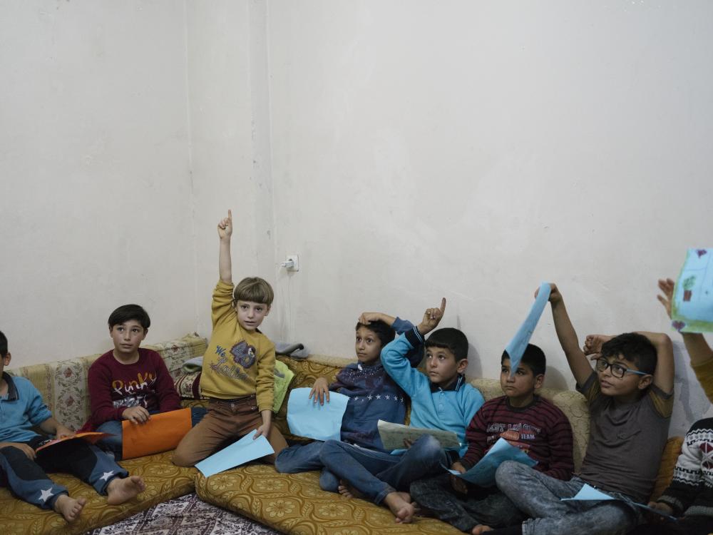 This classroom scene pictures Syrian children in an unofficial school supported by the Turkish NGO "Support to Life." It was taken by Magnum photographer Emin Ozmen, in Hatay, Turkey, in 2018.